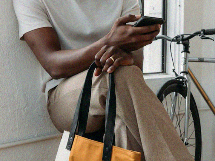 Del av person som håller i mobiltelefon.