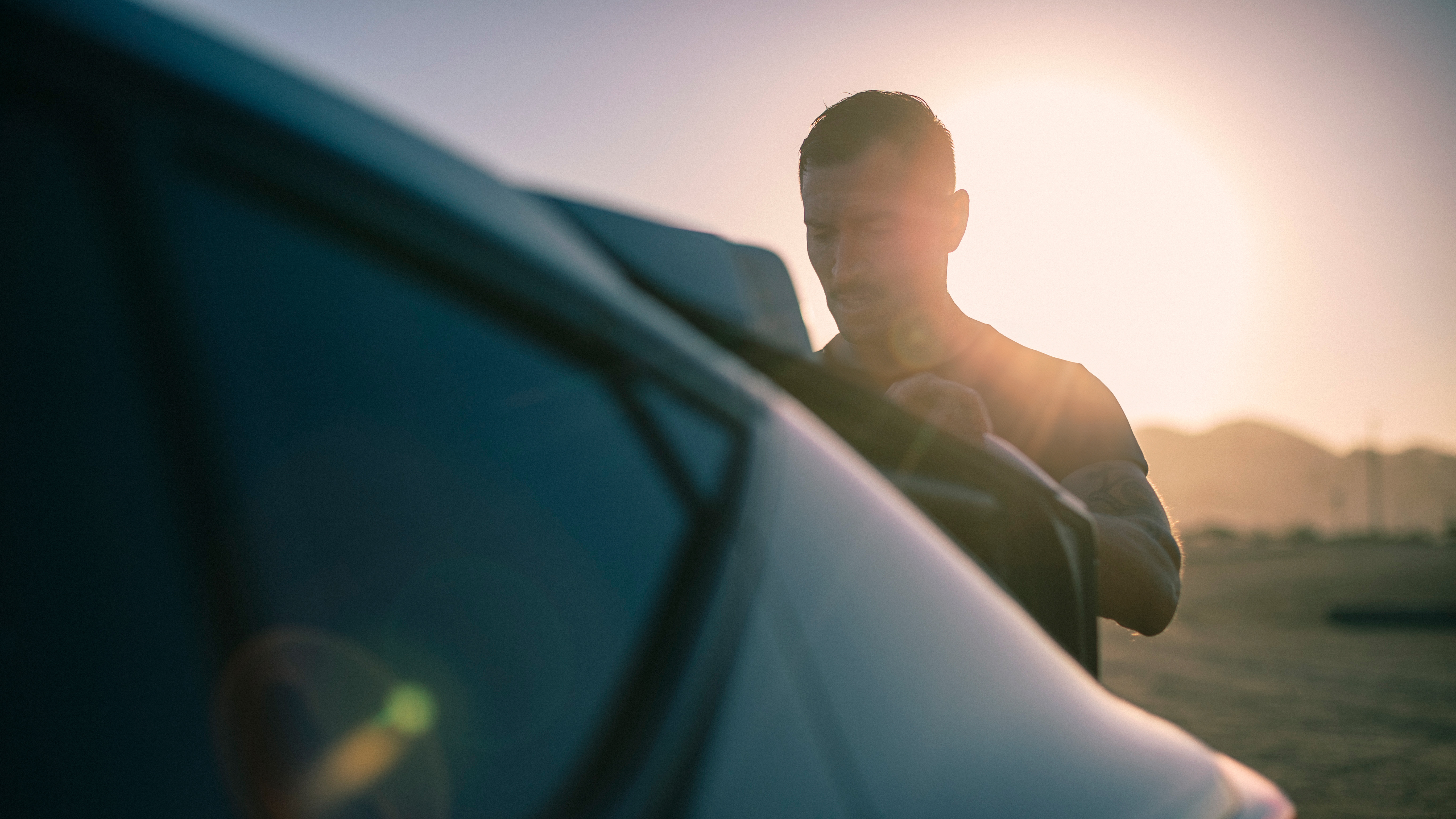 Man vid bil i motljus