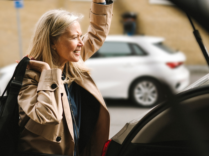 Kvinna stänger bakluckan på en bil