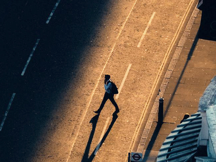 Person går över väg i soluppgång