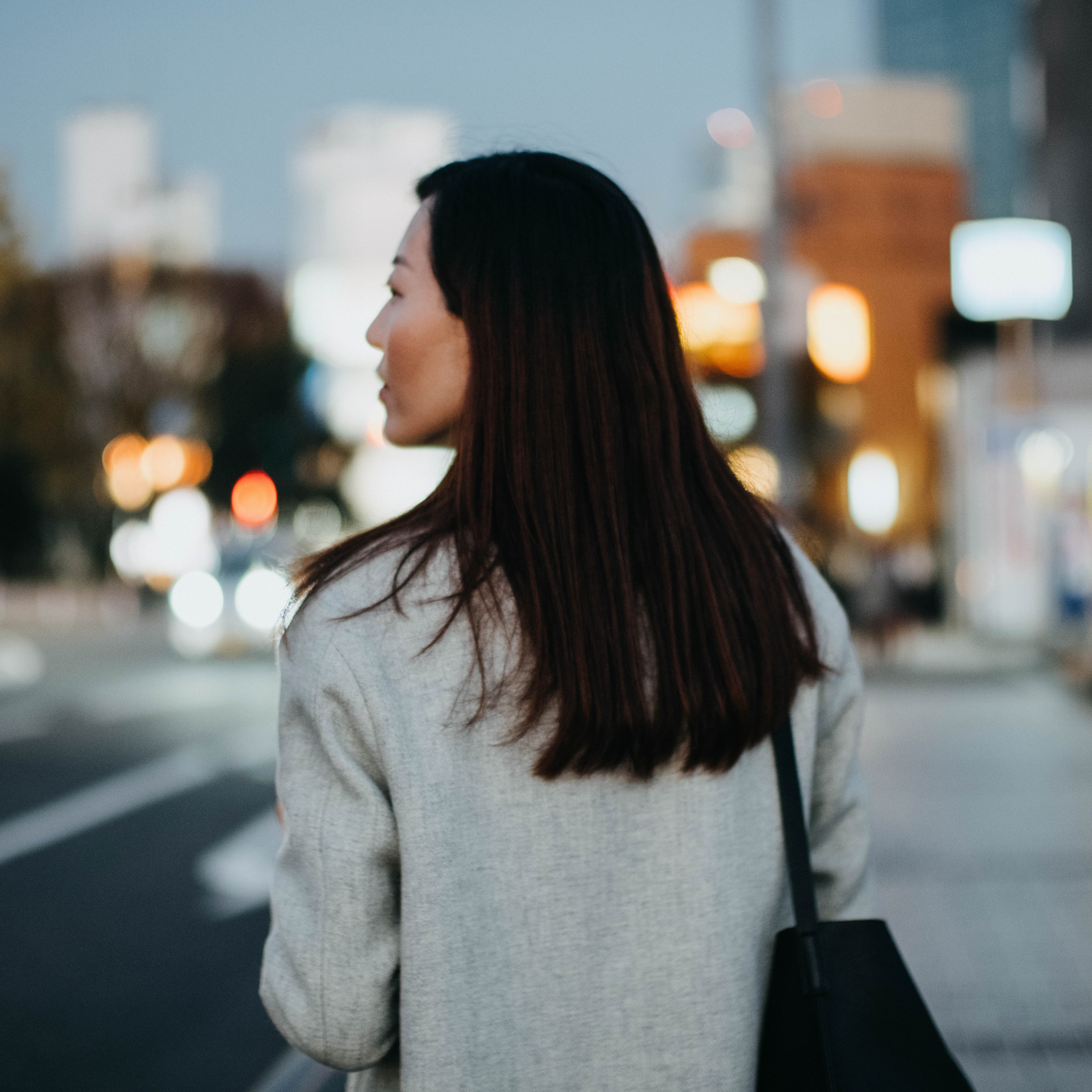 Ryggen på en kvinna som går in en stad. 