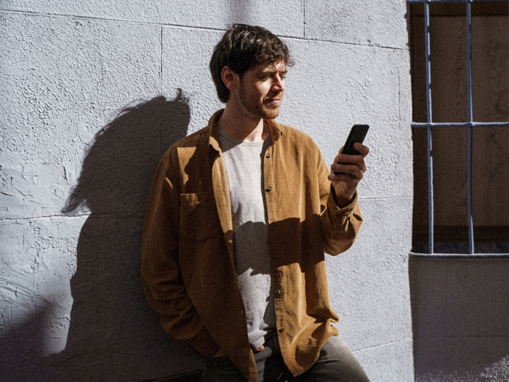 En man som tittar på sin mobiltelefon.