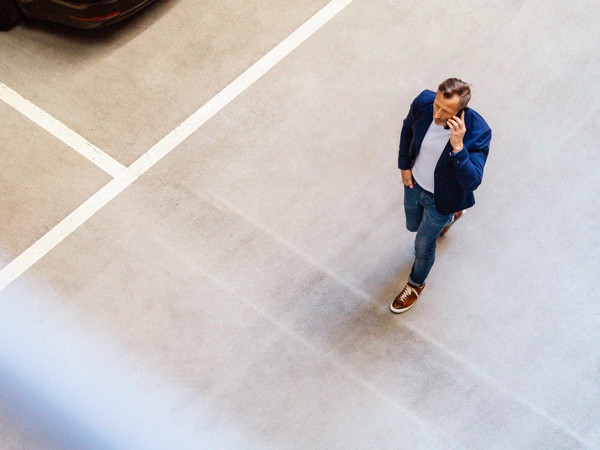 Man går och pratar i mobil i parkeringshus