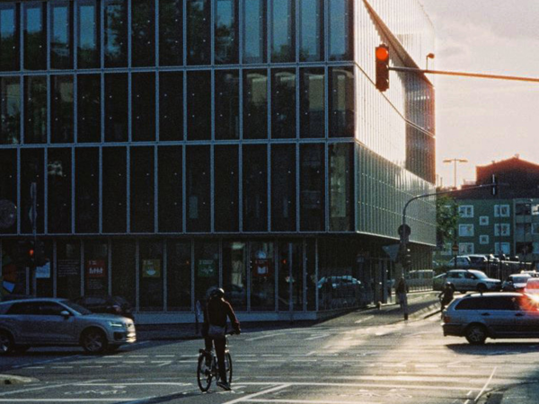 Cykel vid rödljus framför en kontorsbyggnad i solnedgången